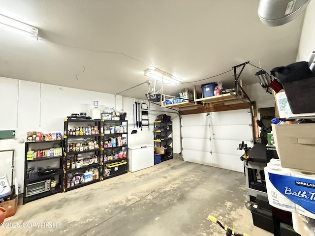 711 Maple Dr, Kenai, AK 99611 - garage featuring a garage door opener and freestanding refrigerator