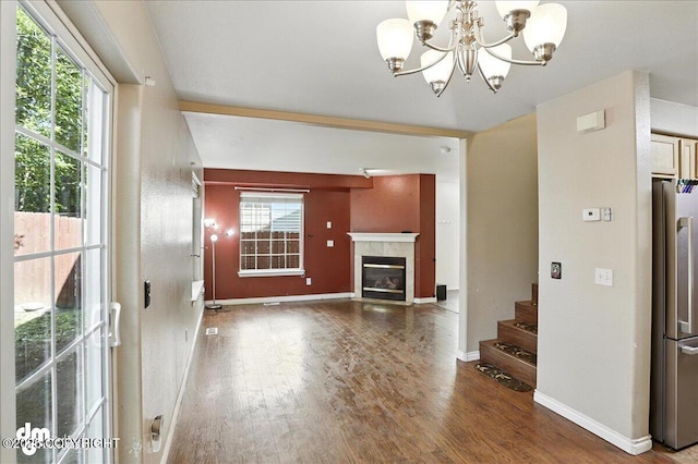 6403 E 10th Ave # 26, Anchorage, AK 99504 - unfurnished living room with wood finished floors, stairway, a chandelier, and a tiled fireplace