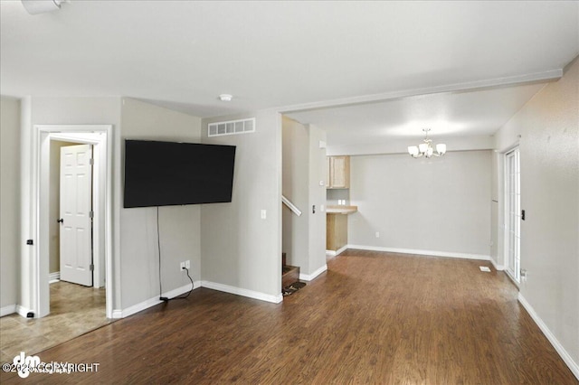 6403 E 10th Ave # 26, Anchorage, AK 99504 - unfurnished living room featuring a chandelier, stairs, and wood finished floors