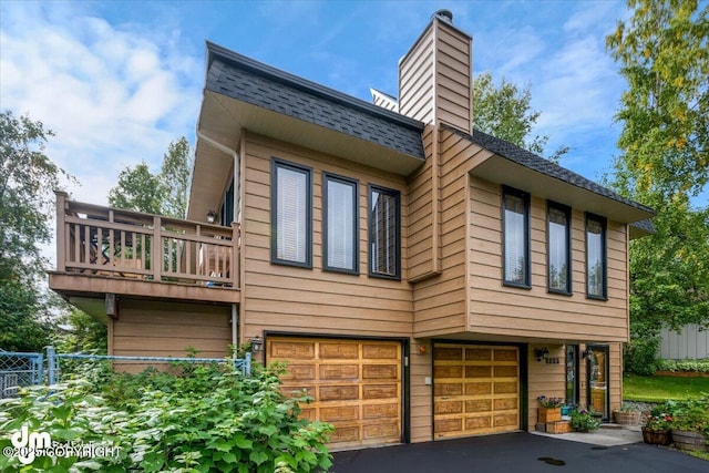 6340 Habicht Ct, Anchorage, AK 99504 - view of property exterior featuring an attached garage, a chimney, roof with shingles, driveway, and a balcony