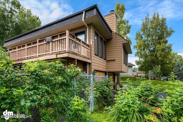 6340 Habicht Ct, Anchorage, AK 99504 - view of side of property with a chimney and a balcony