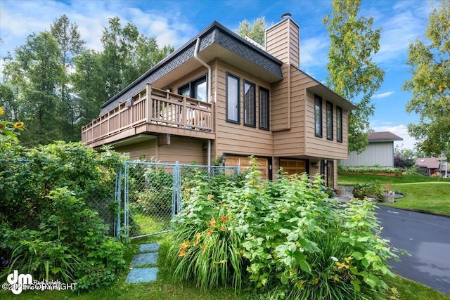 6340 Habicht Ct, Anchorage, AK 99504 - view of home's exterior featuring a balcony, a chimney, an attached garage, and a gate