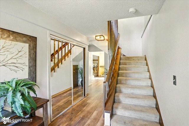 6340 Habicht Ct, Anchorage, AK 99504 - staircase featuring wood finished floors and a textured ceiling