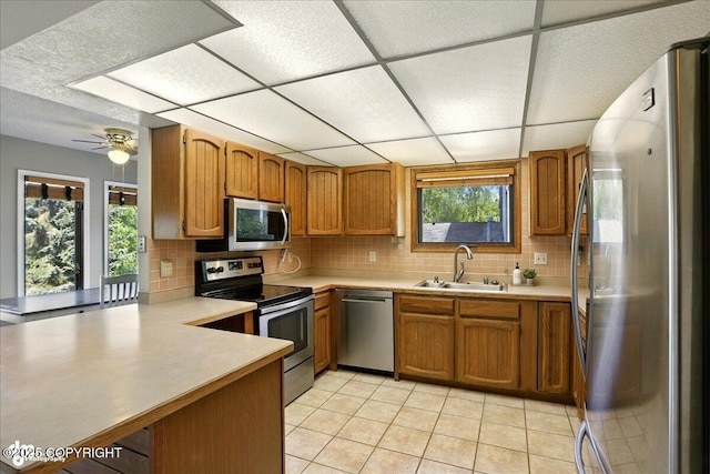 6340 Habicht Ct, Anchorage, AK 99504 - kitchen featuring stainless steel appliances, decorative backsplash, brown cabinetry, light countertops, and a drop ceiling