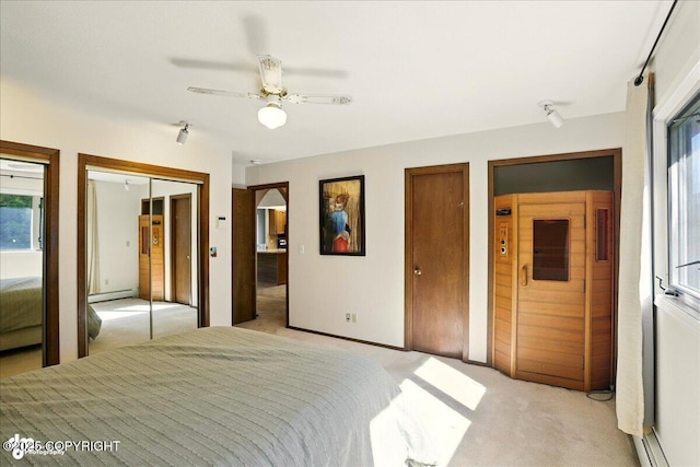 6340 Habicht Ct, Anchorage, AK 99504 - unfurnished bedroom featuring multiple closets, light colored carpet, a baseboard heating unit, track lighting, and ceiling fan