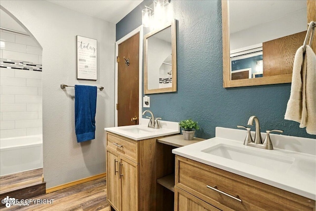 6340 Habicht Ct, Anchorage, AK 99504 - full bath featuring wood finished floors, two vanities, shower / bathtub combination, and a textured wall