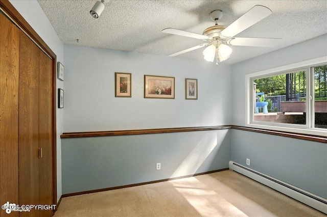 6340 Habicht Ct, Anchorage, AK 99504 - spare room featuring a baseboard heating unit, ceiling fan, a textured ceiling, and light colored carpet