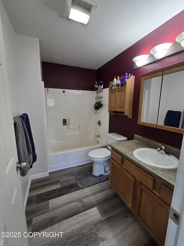 46270 Woodwill Dr, Kenai, AK 99611 - bathroom featuring wood finished floors, vanity, shower / bathtub combination, and a textured ceiling