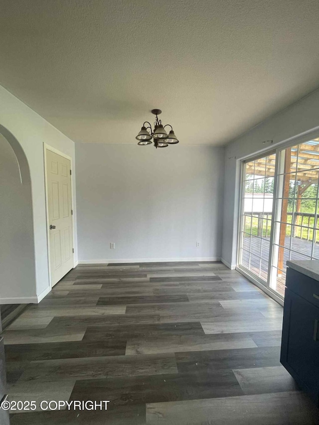 46270 Woodwill Dr, Kenai, AK 99611 - unfurnished dining area featuring a chandelier, arched walkways, wood finished floors, and a textured ceiling