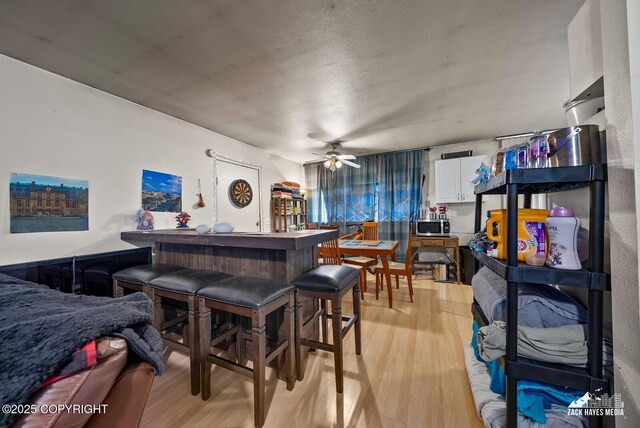 4116 W 88th Ave, Anchorage, AK 99502 - indoor dry bar with stainless steel microwave, light wood-style floors, and a ceiling fan