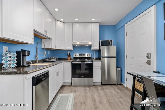 4116 W 88th Ave, Anchorage, AK 99502 - kitchen featuring stainless steel appliances, under cabinet range hood, white cabinets, light wood-type flooring, and recessed lighting