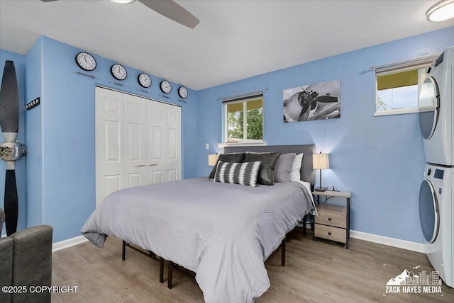 4116 W 88th Ave, Anchorage, AK 99502 - bedroom featuring stacked washer / drying machine, wood finished floors, and a closet