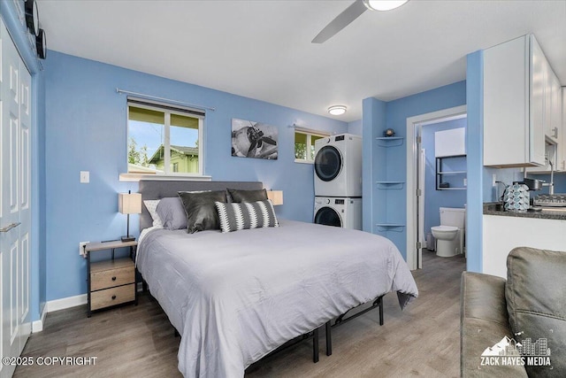 4116 W 88th Ave, Anchorage, AK 99502 - bedroom with stacked washer / drying machine, light wood-style flooring, ensuite bathroom, and ceiling fan