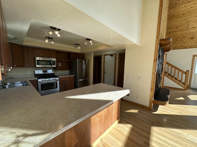 10821 E Valley Crest Dr, Palmer, AK 99645 - kitchen with stainless steel appliances, a raised ceiling, wood finished floors, a peninsula, and crown molding