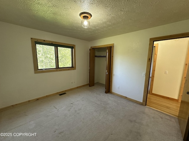 10821 E Valley Crest Dr, Palmer, AK 99645 - unfurnished bedroom featuring a closet, light carpet, and a textured ceiling