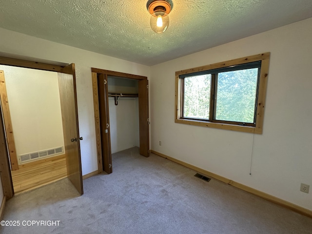 10821 E Valley Crest Dr, Palmer, AK 99645 - unfurnished bedroom featuring light colored carpet, a closet, and a textured ceiling