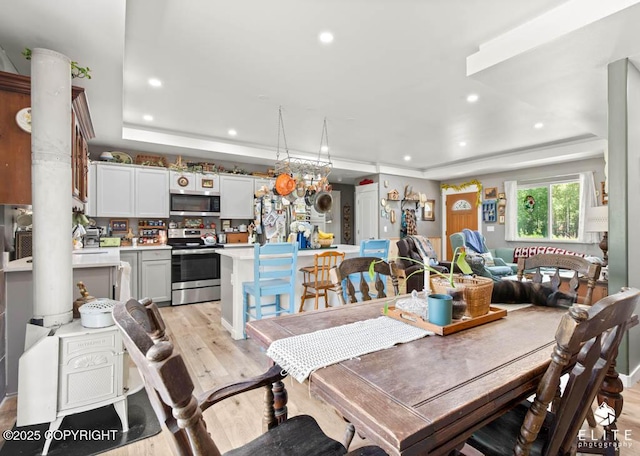 5050 N Gold Mint Dr, Wasilla, AK 99654 - dining area with a tray ceiling, light wood-style floors, and recessed lighting