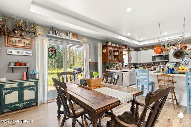 5050 N Gold Mint Dr, Wasilla, AK 99654 - dining space featuring a raised ceiling, light wood-type flooring, and recessed lighting