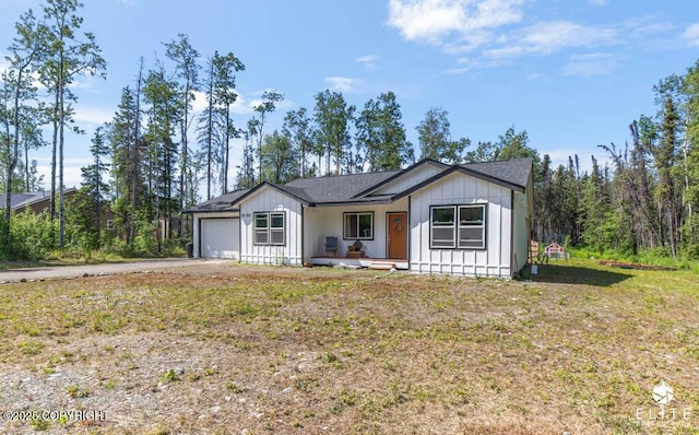5050 N Gold Mint Dr, Wasilla, AK 99654 - view of front of property with an attached garage, board and batten siding, driveway, and covered porch