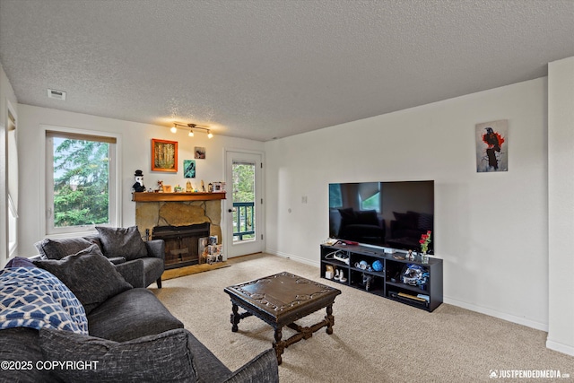 10201 Jamestown Dr # A102, Anchorage, AK 99507 - living area with a textured ceiling, a stone fireplace, and carpet floors