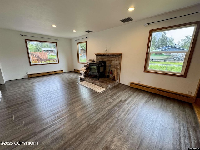 5920 Lund St, Juneau, AK 99801 - unfurnished living room with a baseboard heating unit, wood finished floors, a wood stove, and recessed lighting