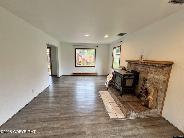 5920 Lund St, Juneau, AK 99801 - unfurnished living room with a baseboard heating unit, a wood stove, wood finished floors, and recessed lighting
