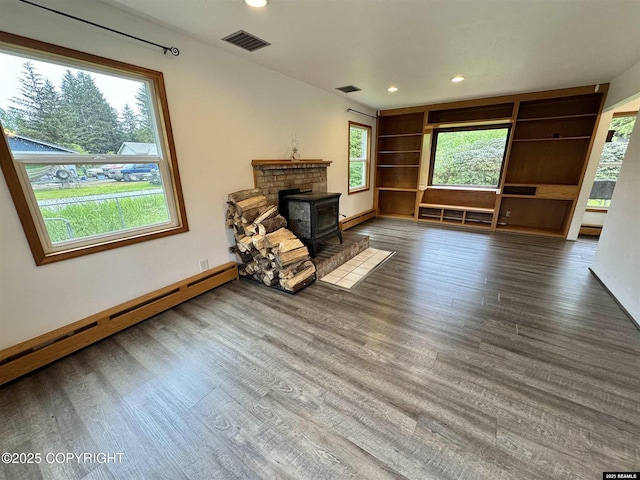 5920 Lund St, Juneau, AK 99801 - unfurnished living room with a wood stove, a baseboard heating unit, wood finished floors, baseboard heating, and recessed lighting