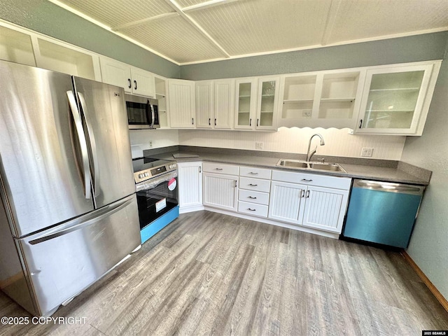 5920 Lund St, Juneau, AK 99801 - kitchen featuring stainless steel appliances, wood finished floors, dark countertops, and white cabinets