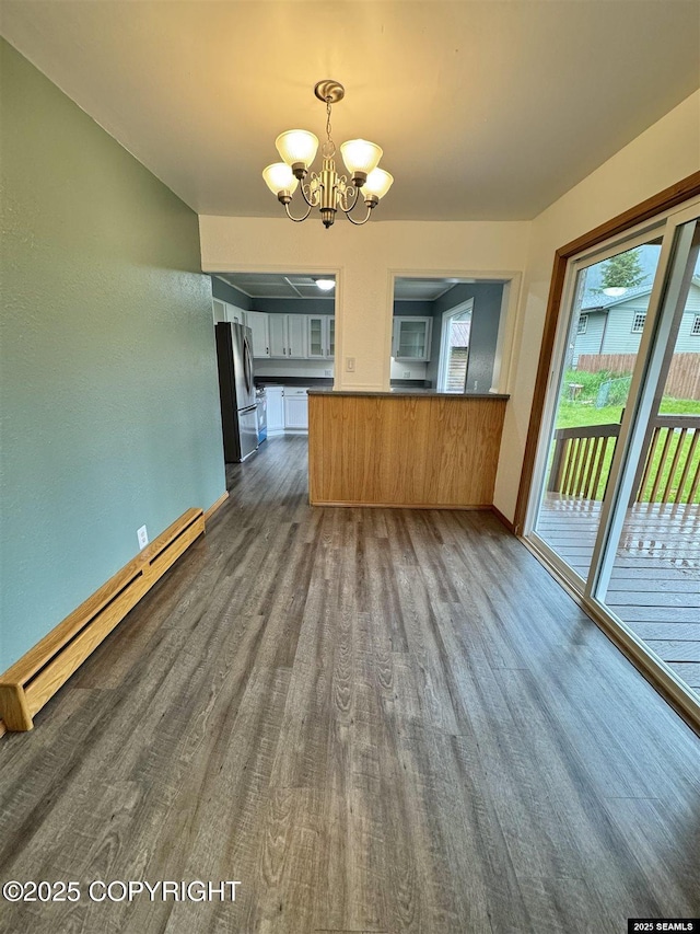 5920 Lund St, Juneau, AK 99801 - kitchen featuring a baseboard heating unit, a chandelier, dark wood-style flooring, freestanding refrigerator, and dark countertops