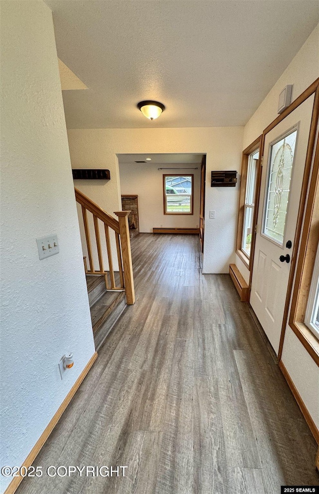 5920 Lund St, Juneau, AK 99801 - entrance foyer featuring wood finished floors, stairs, a textured wall, and a baseboard radiator