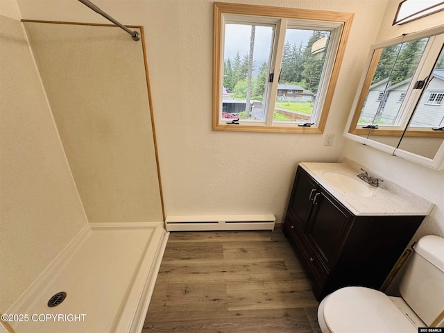 5920 Lund St, Juneau, AK 99801 - full bathroom with baseboard heating, a shower, wood finished floors, and vanity