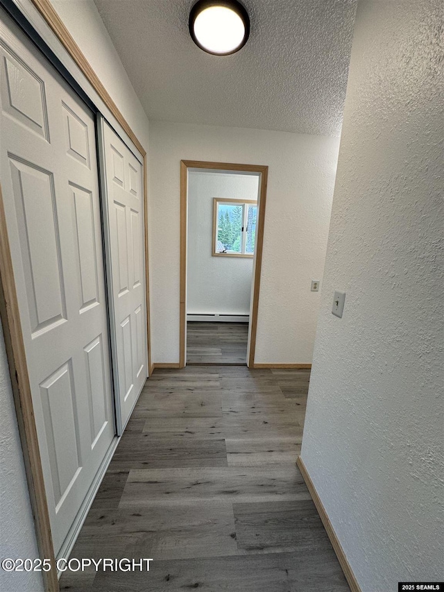 5920 Lund St, Juneau, AK 99801 - corridor with a textured wall, a baseboard radiator, a textured ceiling, and wood finished floors