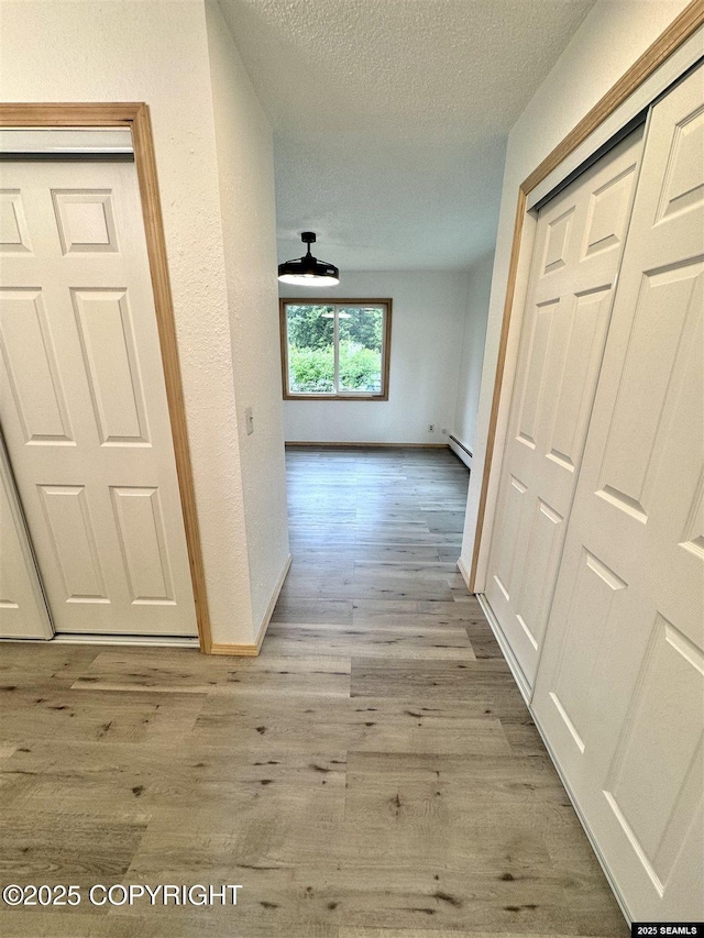 5920 Lund St, Juneau, AK 99801 - hall featuring a textured ceiling, wood finished floors, and a baseboard radiator