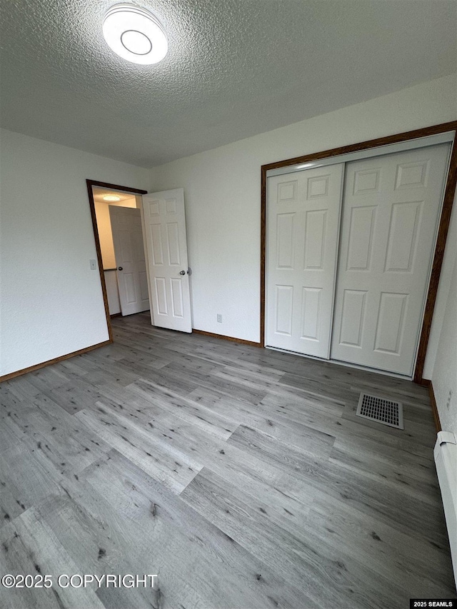 5920 Lund St, Juneau, AK 99801 - unfurnished bedroom featuring wood finished floors, a textured ceiling, and a closet