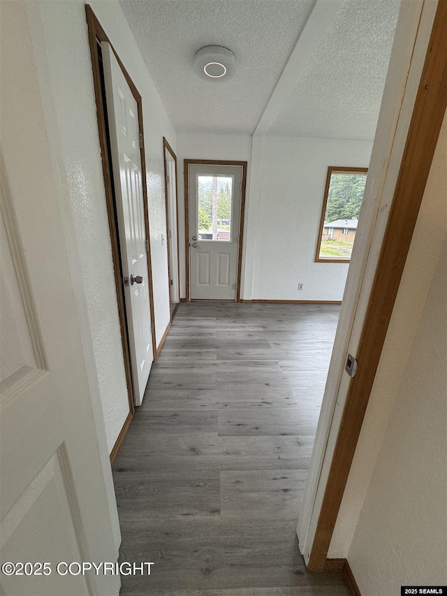 5920 Lund St, Juneau, AK 99801 - hallway featuring a textured ceiling, healthy amount of natural light, and wood finished floors