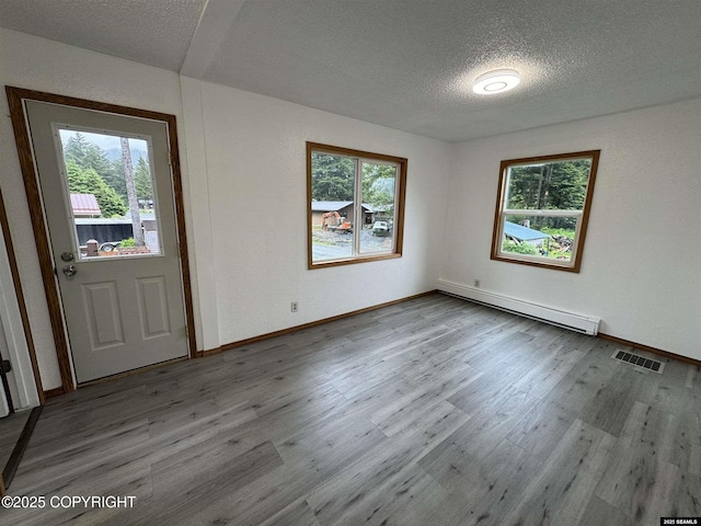5920 Lund St, Juneau, AK 99801 - entrance foyer with a baseboard radiator, a textured ceiling, and wood finished floors