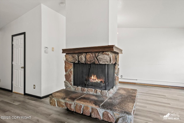 3215 Eastgate Pl # 301, Anchorage, AK 99504 - detailed view of wood finished floors, a baseboard radiator, a fireplace, and a smoke detector