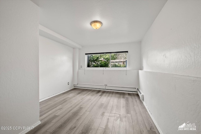 3215 Eastgate Pl # 301, Anchorage, AK 99504 - spare room featuring a baseboard heating unit and wood finished floors