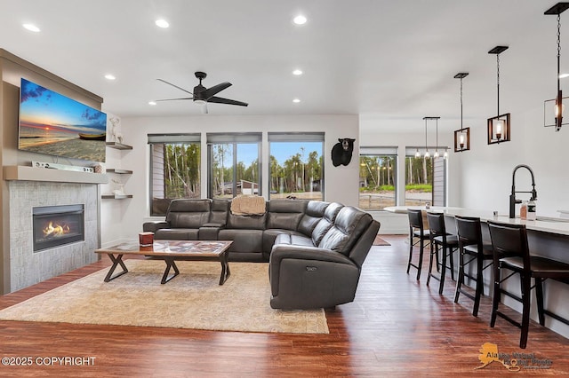4576 S Gon Fishin Dr, Wasilla, AK 99623 - living area with ceiling fan, dark wood-type flooring, a tiled fireplace, recessed lighting, and a chandelier
