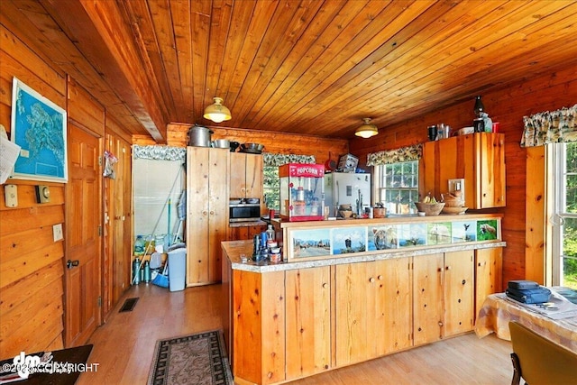 21033 Sterling Hwy, Ninilchik, AK 99639 - kitchen with freestanding refrigerator, wooden ceiling, light wood finished floors, stainless steel microwave, and wood walls