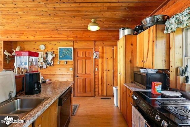 21033 Sterling Hwy, Ninilchik, AK 99639 - kitchen with black appliances, wooden walls, light wood finished floors, and brown cabinetry