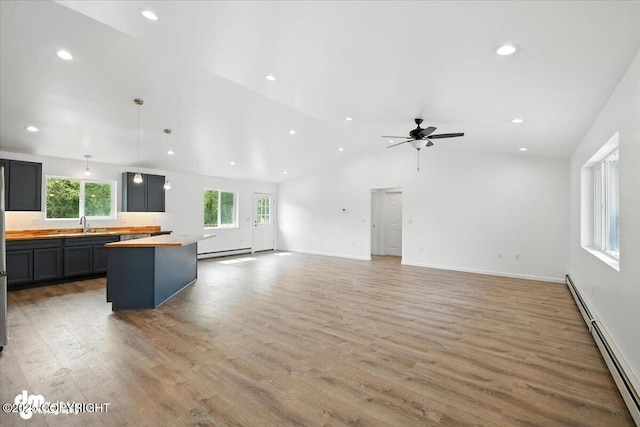 1380 N Cedar Hills Dr, Palmer, AK 99645 - unfurnished living room featuring a baseboard heating unit, lofted ceiling, light wood-style flooring, a ceiling fan, and recessed lighting