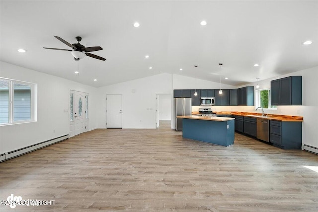 1380 N Cedar Hills Dr, Palmer, AK 99645 - kitchen featuring stainless steel appliances, open floor plan, vaulted ceiling, a baseboard heating unit, and light wood-type flooring