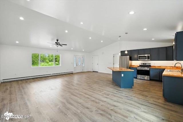 1380 N Cedar Hills Dr, Palmer, AK 99645 - kitchen featuring appliances with stainless steel finishes, butcher block countertops, vaulted ceiling, a baseboard heating unit, and a center island