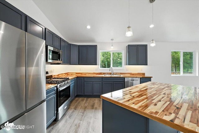 1380 N Cedar Hills Dr, Palmer, AK 99645 - kitchen featuring appliances with stainless steel finishes, butcher block counters, lofted ceiling, light wood-type flooring, and hanging light fixtures