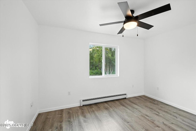1380 N Cedar Hills Dr, Palmer, AK 99645 - unfurnished room with a baseboard radiator, wood finished floors, and a ceiling fan