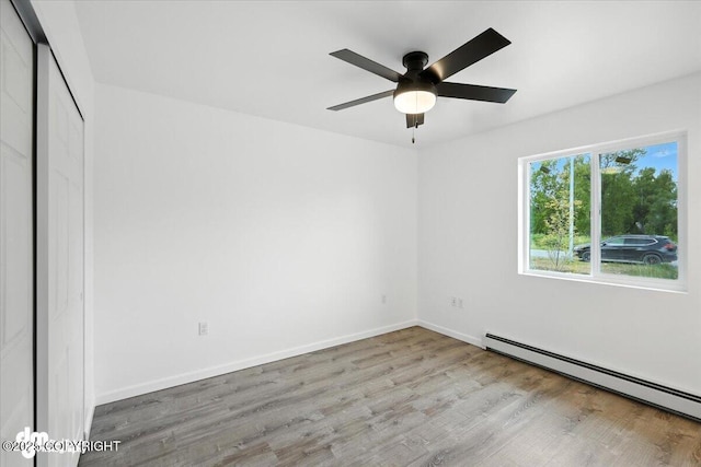 1380 N Cedar Hills Dr, Palmer, AK 99645 - spare room with baseboard heating, wood finished floors, and ceiling fan