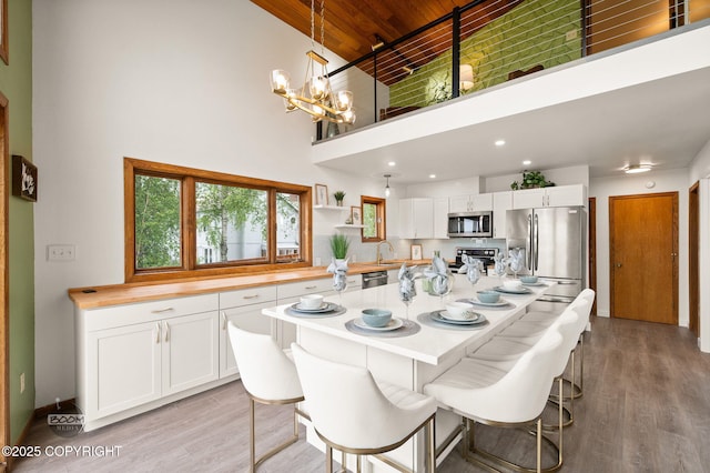 900 W Selina Ln, Wasilla, AK 99654 - dining space with wood ceiling, a high ceiling, a chandelier, light wood-type flooring, and recessed lighting