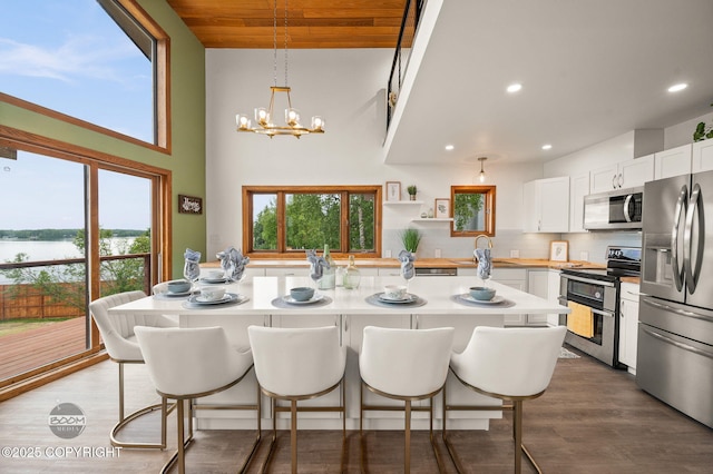 900 W Selina Ln, Wasilla, AK 99654 - kitchen featuring appliances with stainless steel finishes, a breakfast bar, light countertops, white cabinetry, and wood ceiling
