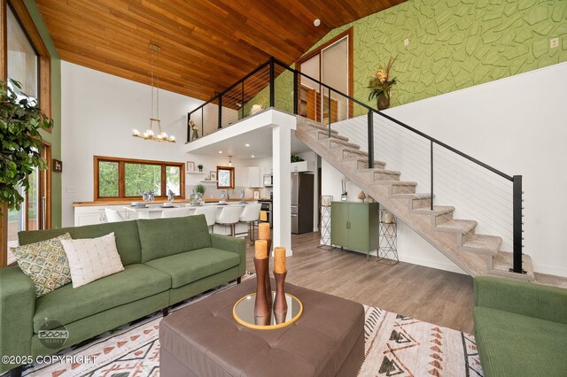 900 W Selina Ln, Wasilla, AK 99654 - living room with high vaulted ceiling, wooden ceiling, stairway, a chandelier, and light wood finished floors
